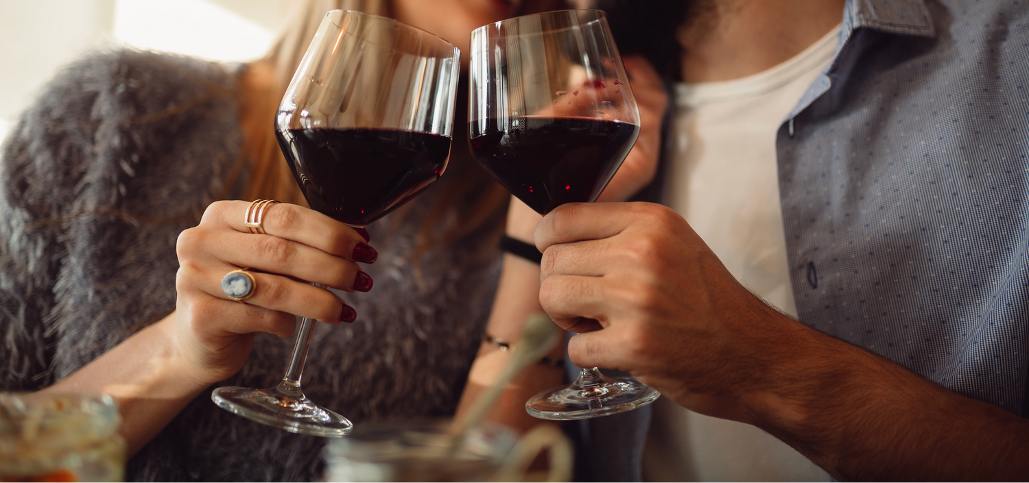 a couple cheersing red wine for date night