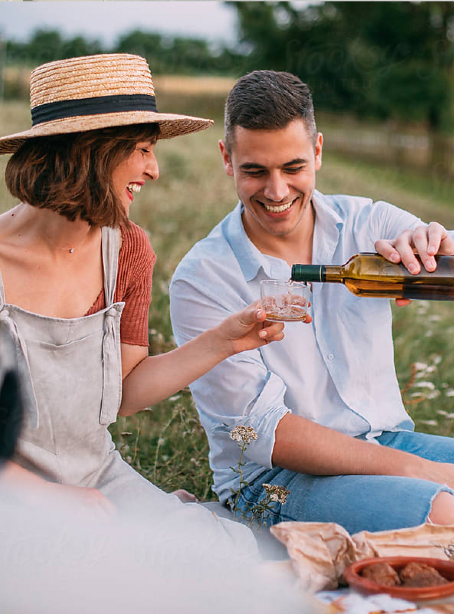 guy pouring wine for woman on a picnic date