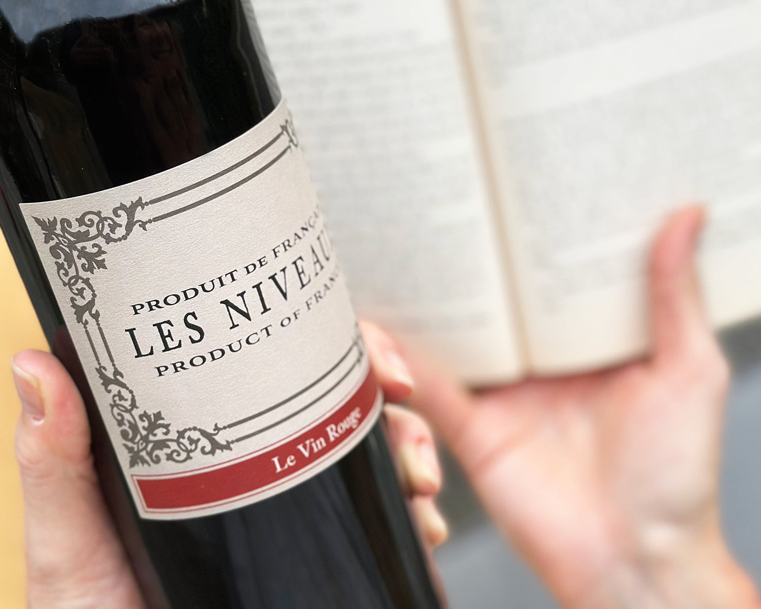 person holding wine and reading book